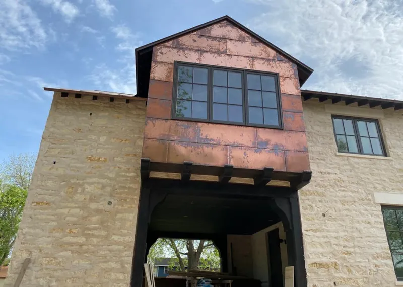 Copper metal panel facade on a stone building for Skylight Installation in Menomonie